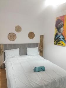 a white bed with a blue hat on it at Akwaba lodge in Sale +67 photos