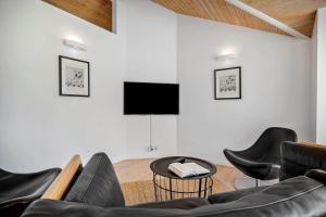 a living room with black chairs and a flat screen tv at K19089-Kalundborg-Granlygardsvej-30 in Ågerup