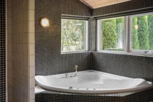a bath tub in a bathroom with two windows at K19089-Kalundborg-Granlygardsvej-30 in Ågerup +14 photos