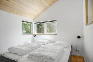a bed in a white room with two windows at K19089-Kalundborg-Granlygardsvej-30 in Ågerup