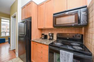 a kitchen with a stove and a microwave at PlanURstay - Ideal 2BR & 2 BTH - Near SQ1 Mall in Mississauga