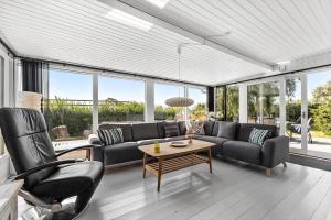 een woonkamer met banken, een tafel en ramen bij SL350-Slagelse-Spaettevej-14 in Store Kongsmark