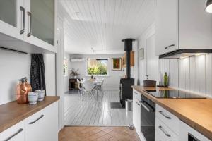 een keuken met witte kasten en een eetkamer bij SL350-Slagelse-Spaettevej-14 in Store Kongsmark +17 foto's