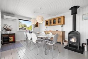een eetkamer met een tafel en stoelen en een fornuis bij SL350-Slagelse-Spaettevej-14 in Store Kongsmark