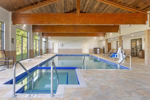 een overdekt zwembad met blauwe tegelvloeren en een houten plafond bij Best Western Plus Eau Claire Conference Center in Eau Claire