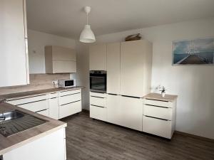 a white kitchen with white cabinets and a sink at Top Ferien- und Monteurswohnungen in Taucha bei Leipzig Nähe A14 in Taucha