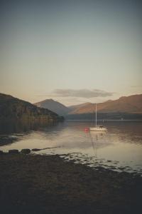 een boot in het midden van een waterlichaam bij NICHT' Apartments Inveraray Town Centre in Inveraray