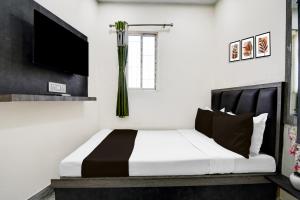 a bedroom with a black and white bed and a tv at Hotel O S. R. ROYALE in Kolkata
