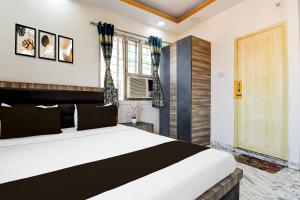 a bedroom with a large bed and a window at Hotel O S. R. ROYALE in Kolkata