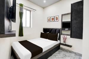 a bedroom with a white bed and a window at Hotel O S. R. ROYALE in Kolkata