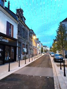 Una calle de la ciudad con coches aparcados en la calle. en Duplex chic et pratique, en Nogent-sur-Seine