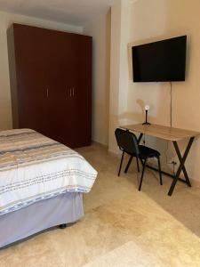 a bedroom with a bed and a desk with a television at Sole 1 