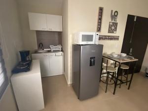 a small kitchen with a microwave on top of a refrigerator at Sole 1 
