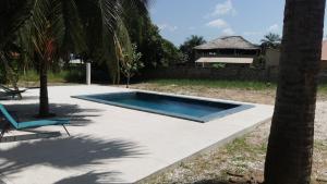 a swimming pool in a yard with a palm tree at Chambre a cap skirring avec acces piscine in Cap Skirring +3 photos