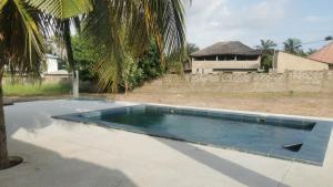 a swimming pool in a yard with a house at Chambre a cap skirring avec acces piscine in Cap Skirring