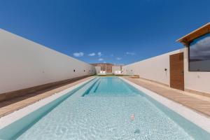 ein Infinity-Pool in einem Haus mit weißer Wand in der Unterkunft Esencia House Bajo las Estrellas in Llanos de la Concepción