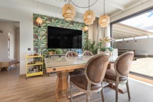 ein Esszimmer mit Tisch und Stühlen und einem Fernseher in der Unterkunft Esencia House Bajo las Estrellas in Llanos de la Concepción
