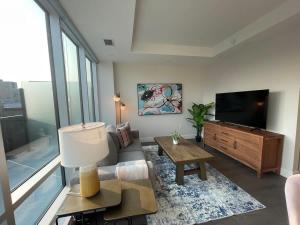 a living room with a television and a table at Downtown bright and modern 1 BR with 6 appliances in Halifax