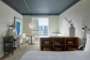 a bedroom with a bed and a desk and a table at One Hundred Shoreditch in London +68 photos