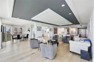 a living room with couches and a dining room at Sophisticated Three-Bedroom Coastal Apartment with Fireplace in Naples