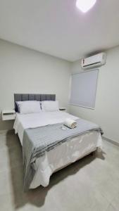 een witte slaapkamer met een bed en een schoolbord bij Apartamento Completo aconchegante- Fácil acesso ao Aeroporto e a COP-30 in Belém +15 foto's