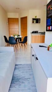 een kamer met een keuken en een tafel en stoelen bij Apartamento Completo aconchegante- Fácil acesso ao Aeroporto e a COP-30 in Belém