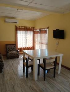 una sala da pranzo con tavolo e sedie bianchi di Rincón de Santa Tecla a Puerto Valle