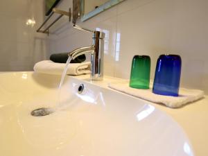 a bathroom sink with a water faucet and two glasses at Petit Wilogne in Dinez +44 photos