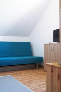 Sofá azul en una habitación con TV en Baltic-House, en Gąski