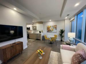 a living room with a large television and a table at Spotless & Bright 1 BR downtown with private patio in Halifax