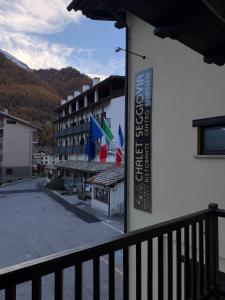 a sign on the side of a building with flags at Hotel Chalet Seggiovia in Pontechianale