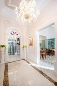 a living room with a chandelier and a dining room at Ta' Dun Martin and taz-Zija Bed and Breakfast in Nadur