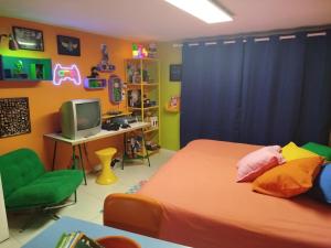 a bedroom with a bed and a desk with a computer at Flashbackroom #Retour dans les années 80 90 in Clermont-Ferrand