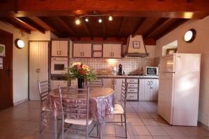 a kitchen with a table with chairs and a refrigerator at Salatua in Musculdy