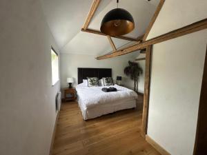 Un dormitorio con una cama y suelo de madera. en Tranquil detached barn in Sherborne St John, en Sherborne Saint John 7 fotos más