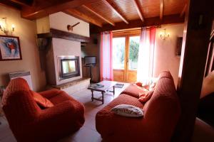 a living room with two red chairs and a television at Salatua in Musculdy
