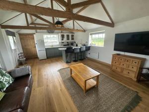 una sala de estar con un sofá y una mesa en Tranquil detached barn in Sherborne St John, en Sherborne Saint John