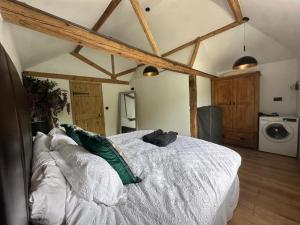 Un dormitorio con una gran cama blanca en una habitación. en Tranquil detached barn in Sherborne St John, en Sherborne Saint John