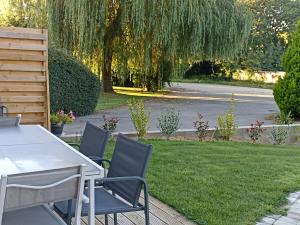 a table and chairs in a yard with a tree at Gite Haute Epine "Ma Vie Là " Studio avec cuisine in Haute-Épine