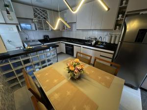 a kitchen with a table with a vase of flowers on it at Ap Cop 30 in Belém