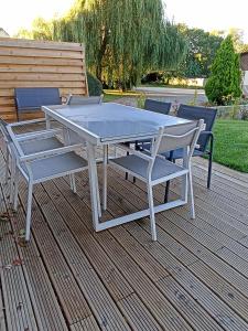 a white picnic table and chairs on a deck at Gite Haute Epine "Ma Vie Là " Studio avec cuisine in Haute-Épine