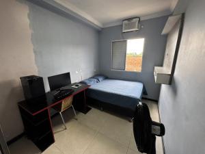a small room with a bed and a desk with a computer at Ap Cop 30 in Belém