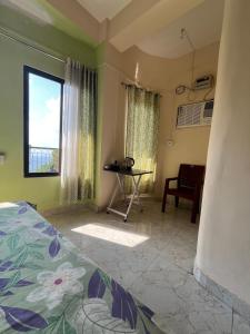 古瓦哈提Hemalata Hilltop Residency Kamakhya的一间卧室，里面有一张床、一张桌子和一扇窗户