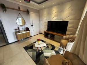 a living room with a flat screen tv on a wall at Ap Cop 30 in Belém