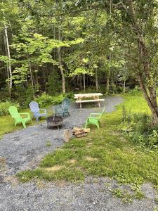 a group of benches and a picnic table in a park at Cozy Secluded Cabin with Fire Pit and Barbecue in Greenville, Maine in Greenville