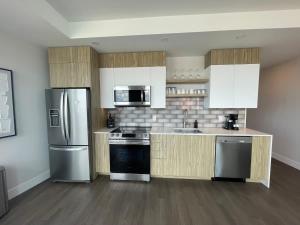 a kitchen with stainless steel appliances and wooden cabinets at Waterfront downtown 1 Bedroom with 6 appliances in Halifax