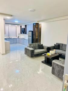 a large living room with couches and a kitchen at Zurich Furnished Apartments in Al Mafraq