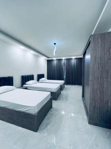 a room with four beds in a room with at Zurich Furnished Apartments in Al Mafraq +11 photos