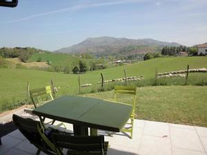 una mesa y sillas con vistas a un campo en Lur-xuri-bidean, en Louhossoa
