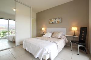 Un dormitorio con una cama y una ventana y una silla. en Lur-xuri-bidean, en Louhossoa